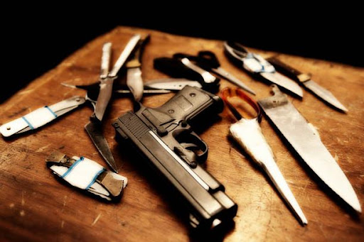 Array of Weapons Laid Out on a Wooden Table