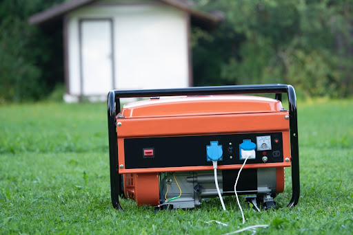 Portable Electric Generator With Wires Sitting on Lawn